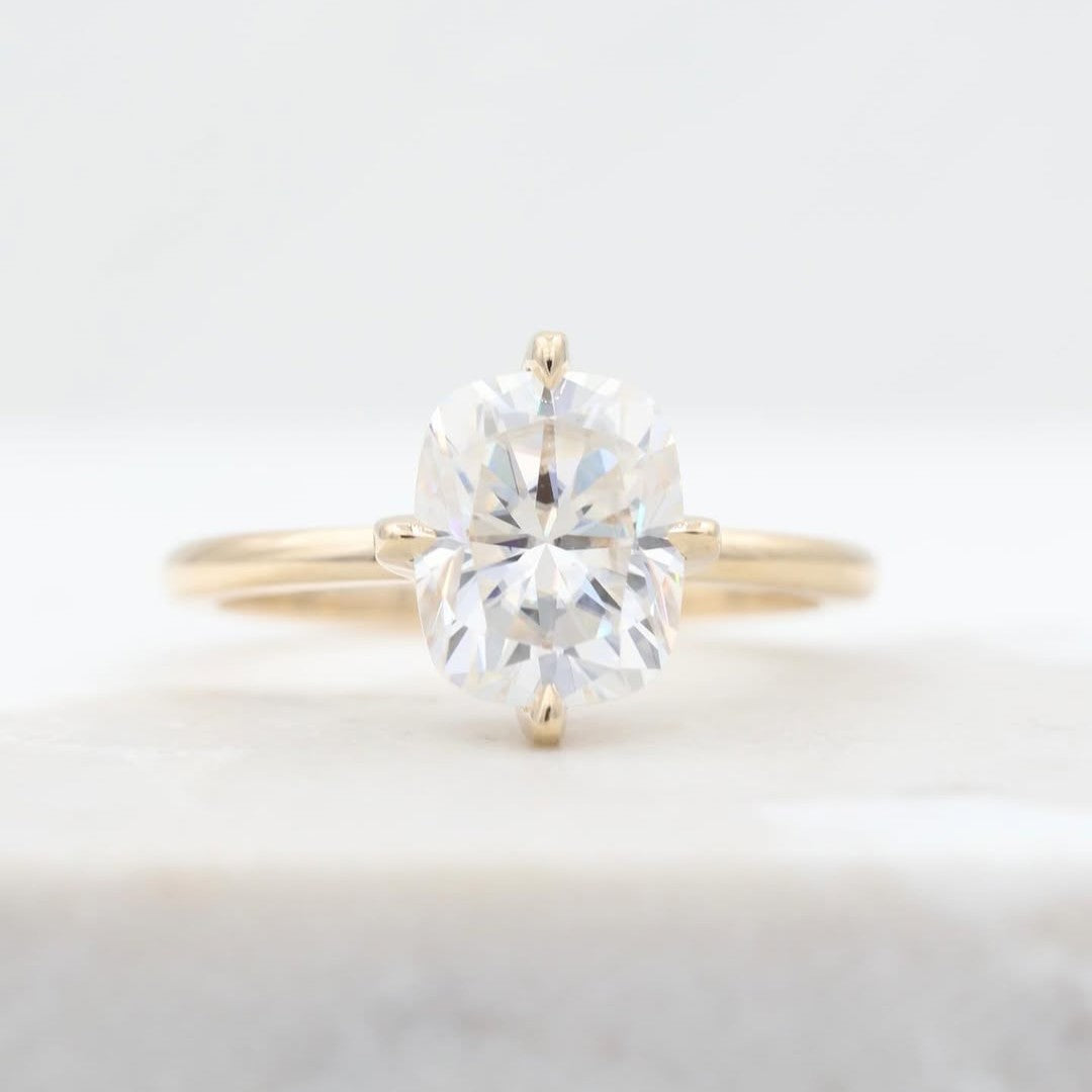 Elongated Cushion Moissanite with center set prongs on 14k yellow gold.